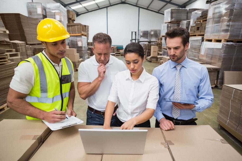 Employees-looking-a-laptop-in-a-warehouse-1024x683